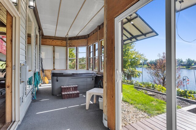 sunroom / solarium with a jacuzzi and a water view