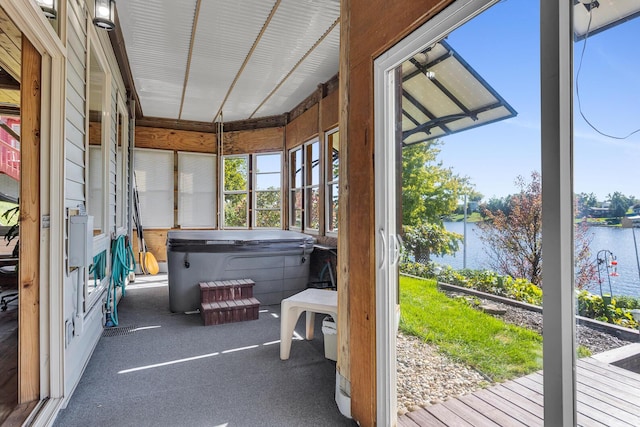 sunroom featuring a jacuzzi and a water view