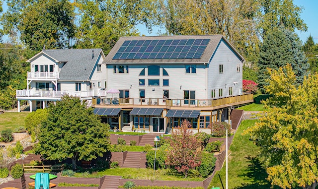 rear view of house with solar panels and a deck