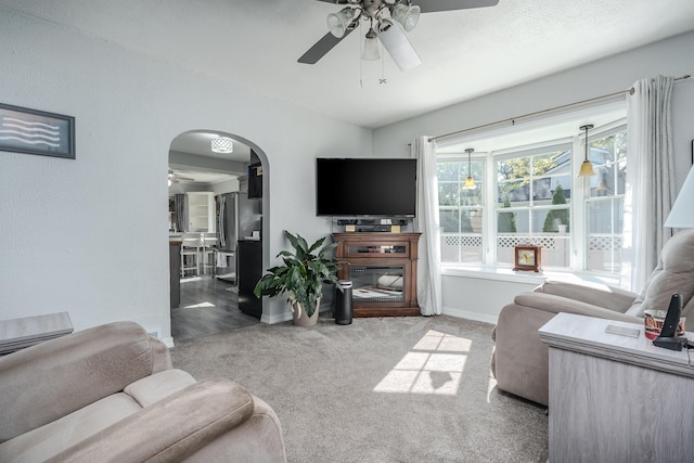 carpeted living room with ceiling fan