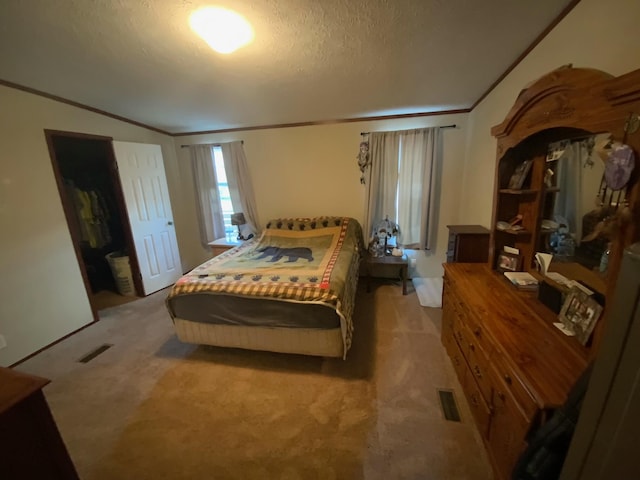 bedroom featuring light colored carpet and a textured ceiling