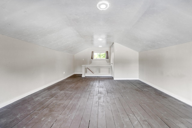 additional living space featuring dark hardwood / wood-style floors and vaulted ceiling