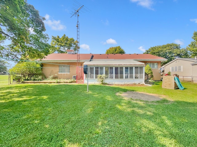 back of house with a sunroom and a yard