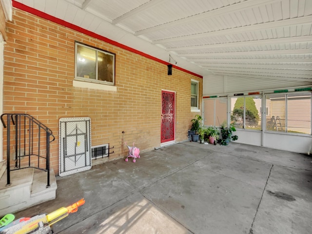 unfurnished sunroom featuring vaulted ceiling