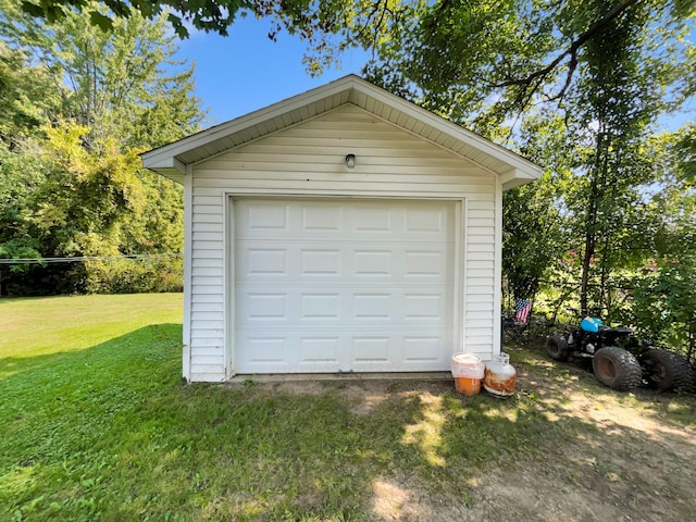 garage featuring wood walls and a yard