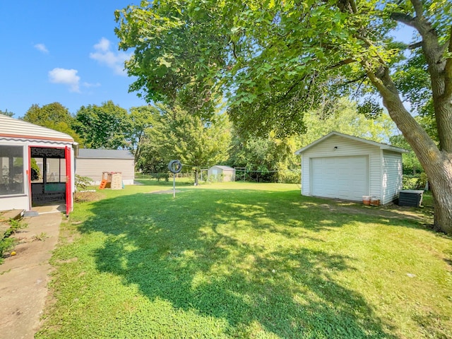 view of yard featuring central AC unit, an outdoor structure, and a garage