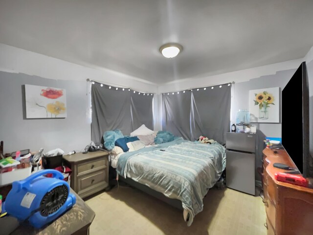 bedroom featuring stainless steel refrigerator