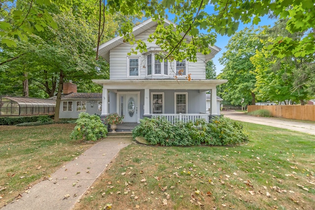 front facade with a front yard and covered porch