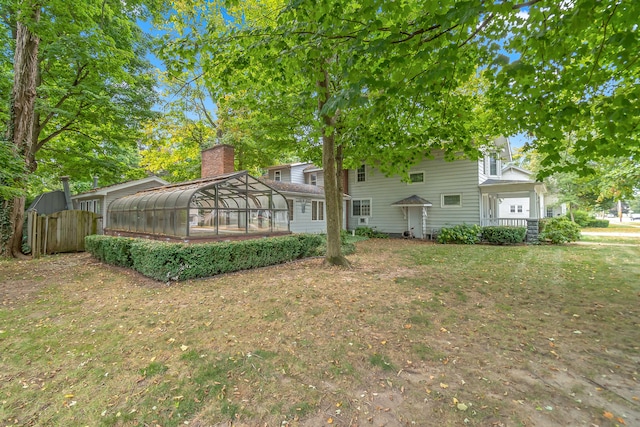 rear view of property featuring a yard