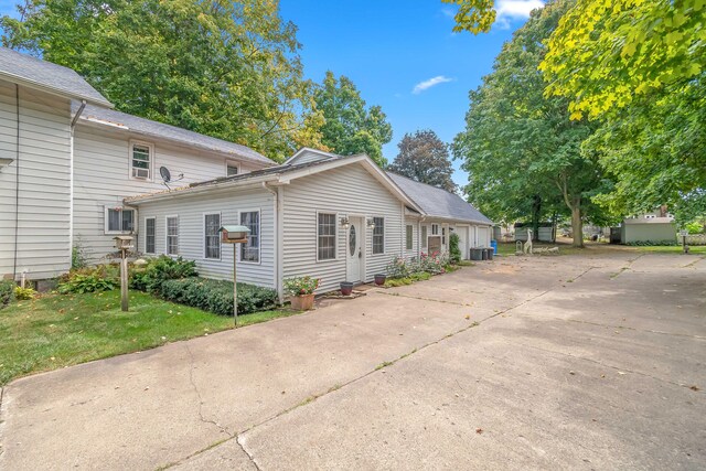 view of front of property with cooling unit and a front yard