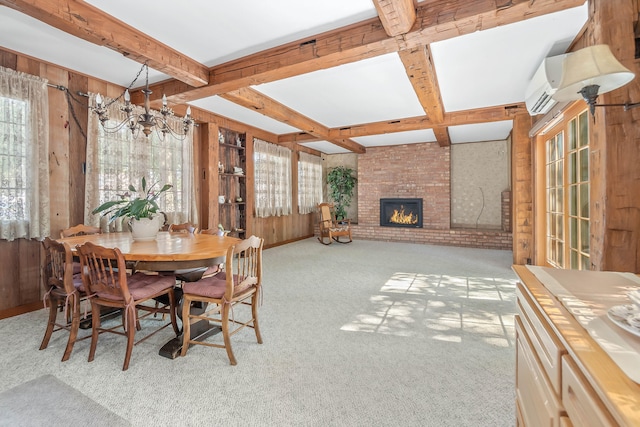 dining area with a brick fireplace, wood walls, and light colored carpet