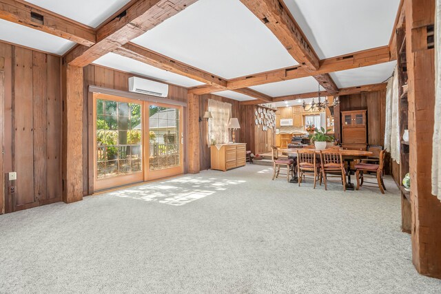 dining space featuring wood walls, light carpet, beamed ceiling, and a wall unit AC