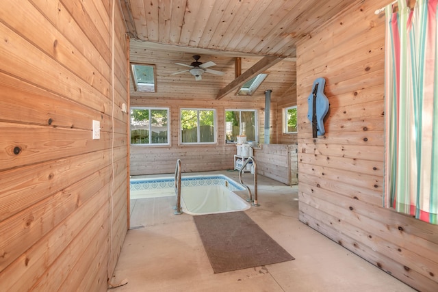 interior space with concrete flooring, wood walls, high vaulted ceiling, and wooden ceiling