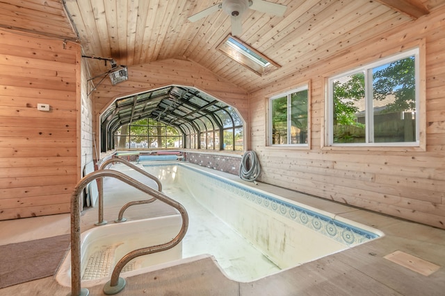 view of pool with an indoor hot tub, a skylight, and ceiling fan