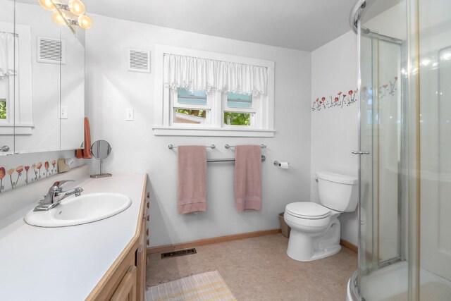 bathroom with vanity, a shower with shower door, and toilet