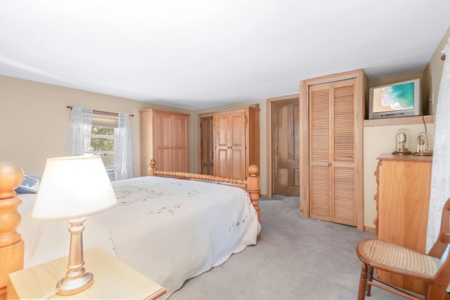 bedroom with light colored carpet and a closet