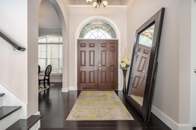 entryway featuring dark hardwood / wood-style flooring, crown molding, plenty of natural light, and a notable chandelier