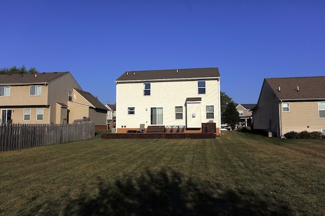 rear view of property with a wooden deck and a lawn