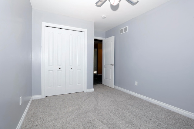 unfurnished bedroom featuring ceiling fan, a closet, and carpet flooring