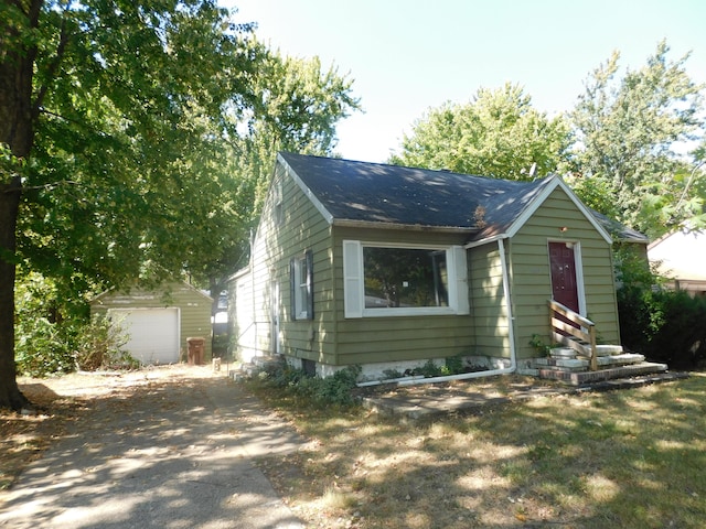 view of front of house with an outbuilding, a garage, and a front lawn