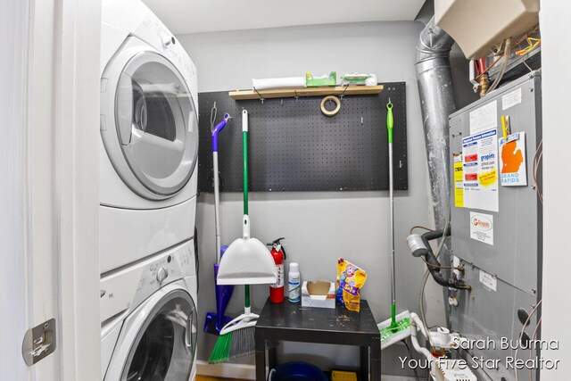 laundry area with heating unit and stacked washer and dryer