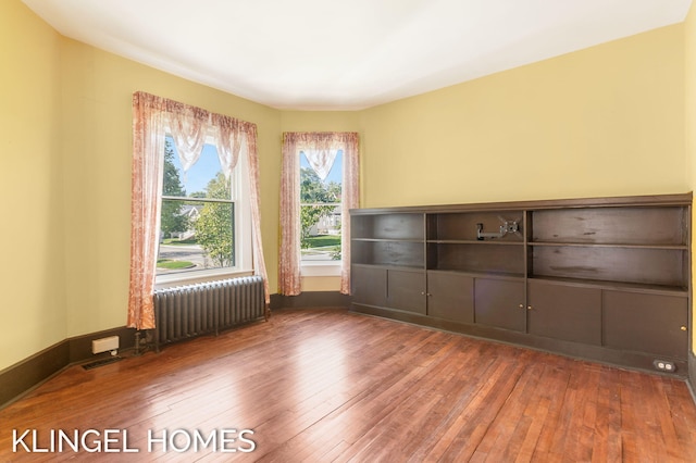 unfurnished room with radiator and hardwood / wood-style flooring