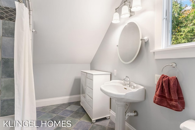 bathroom featuring a shower with shower curtain, lofted ceiling, and toilet