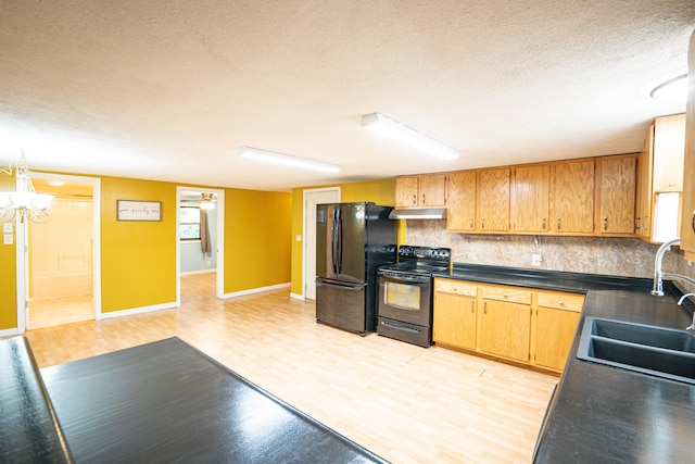 kitchen featuring a textured ceiling, tasteful backsplash, sink, light hardwood / wood-style flooring, and black appliances