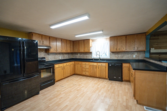 kitchen featuring light hardwood / wood-style floors, sink, tasteful backsplash, and black appliances