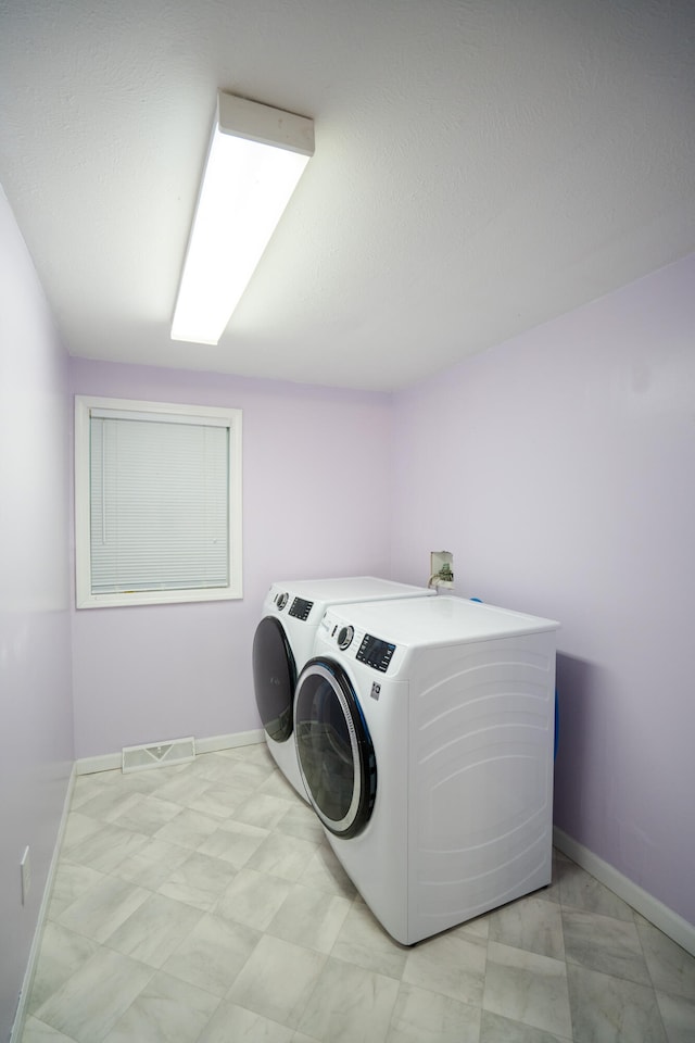 clothes washing area with washer and clothes dryer