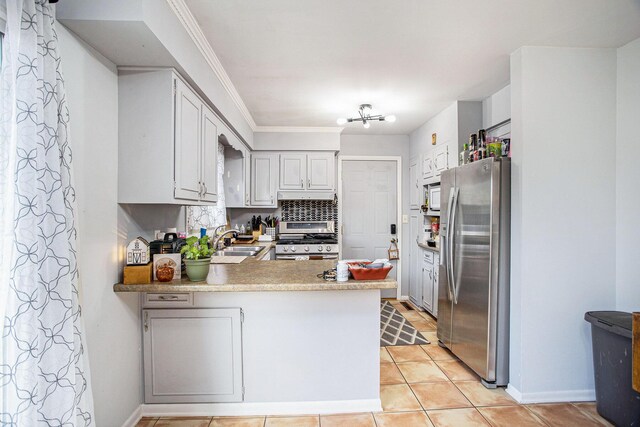 kitchen featuring appliances with stainless steel finishes, light tile patterned flooring, kitchen peninsula, crown molding, and sink