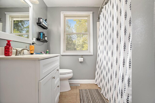 bathroom featuring vanity, plenty of natural light, toilet, and tile patterned floors