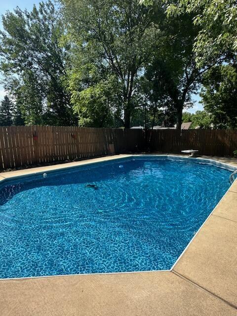 view of swimming pool with a diving board