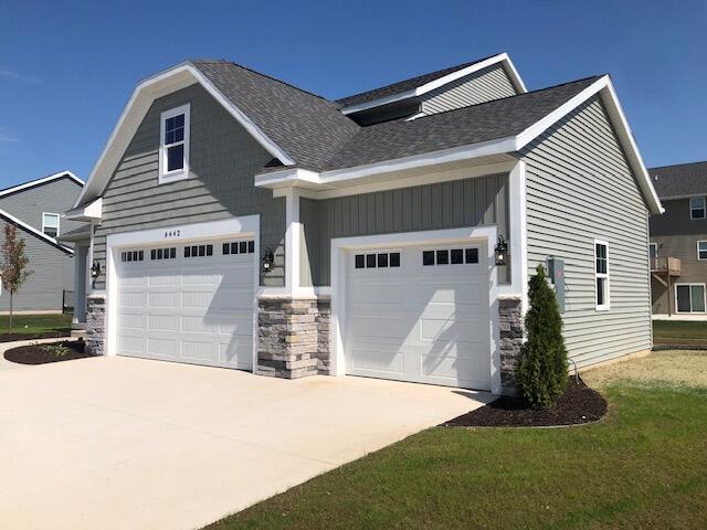 view of side of home with a garage and a lawn