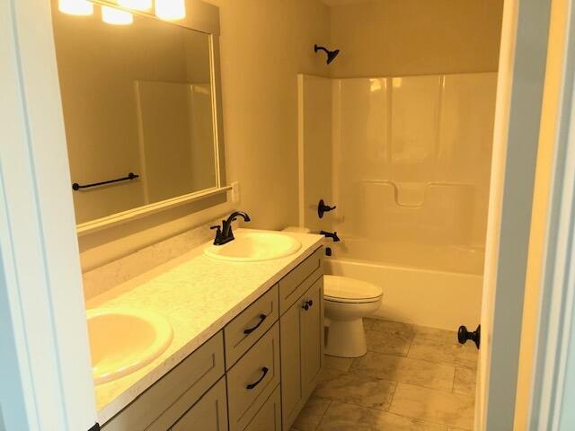 full bathroom featuring  shower combination, vanity, and toilet