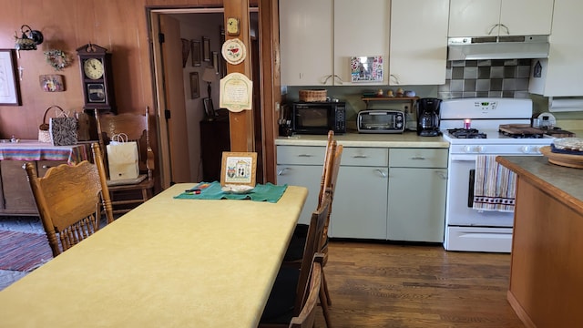 kitchen with backsplash, white cabinetry, dark hardwood / wood-style flooring, and white gas stove