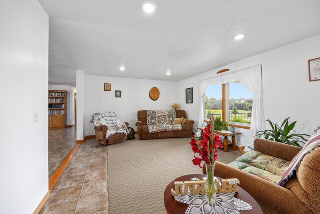 living room with a textured ceiling and light tile patterned floors