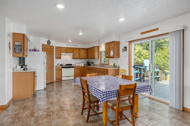 dining space with light tile patterned floors, a textured ceiling, and sink