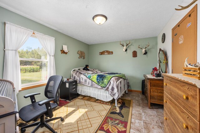 bedroom featuring a textured ceiling and light tile patterned floors