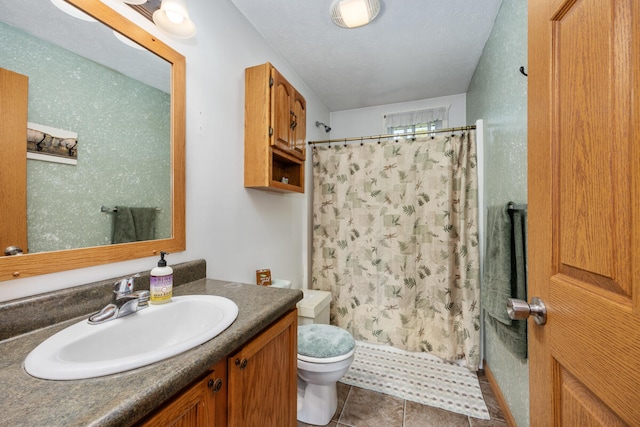 bathroom with a shower with curtain, vanity, a textured ceiling, toilet, and tile patterned floors