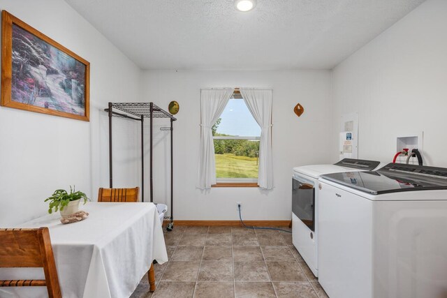 clothes washing area with light tile patterned floors, a textured ceiling, and independent washer and dryer