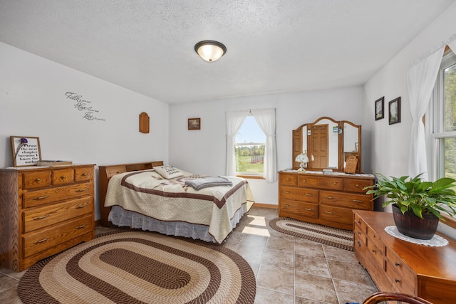 bedroom with a textured ceiling and light tile patterned flooring