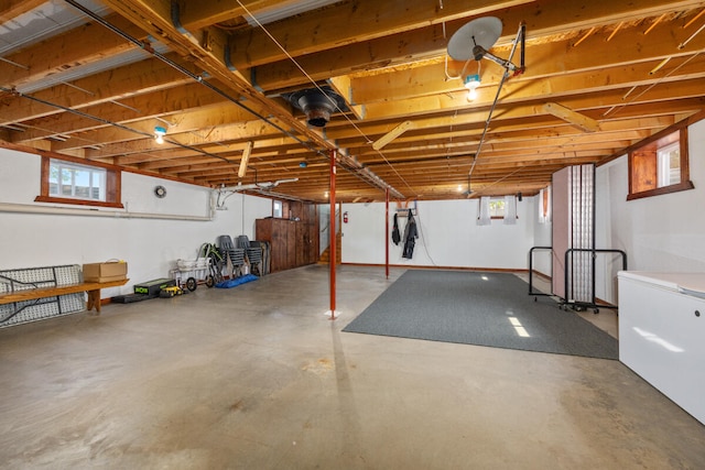 basement featuring a healthy amount of sunlight and refrigerator