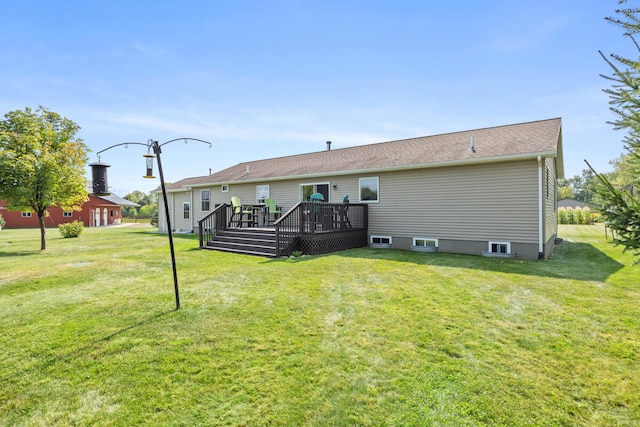 rear view of property with a wooden deck and a lawn