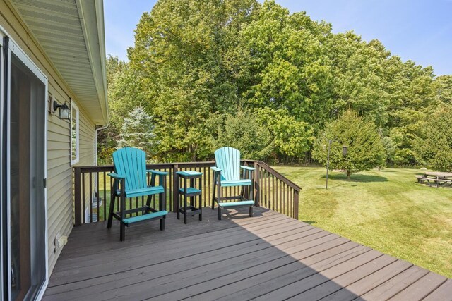 wooden deck featuring a lawn