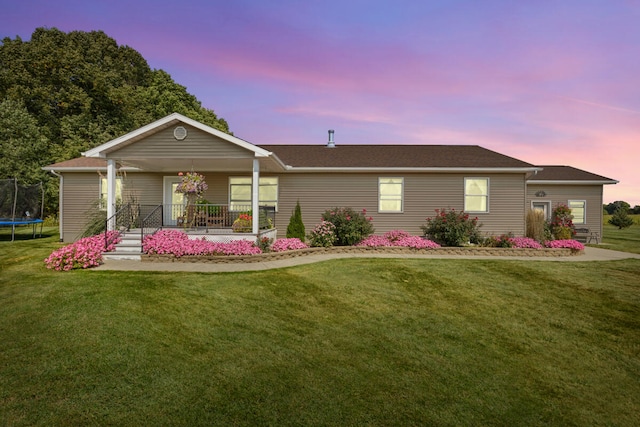 ranch-style house with a trampoline and a yard