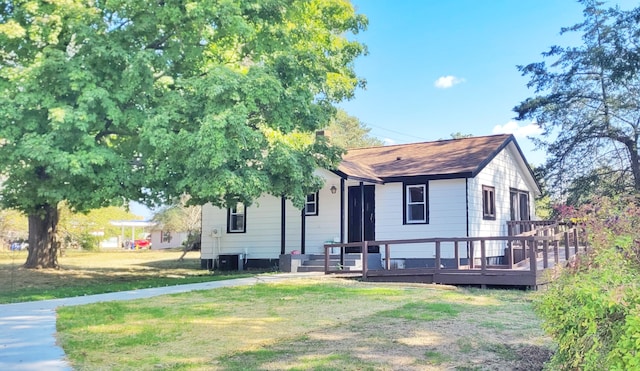 view of front of house with cooling unit, a wooden deck, and a front yard