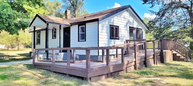 rear view of house with a yard and a wooden deck