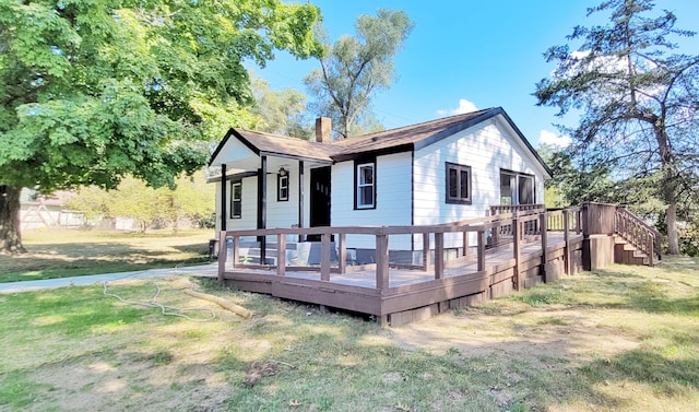 back of house featuring a deck and a lawn