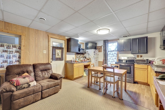 living room with sink, light hardwood / wood-style flooring, and a drop ceiling